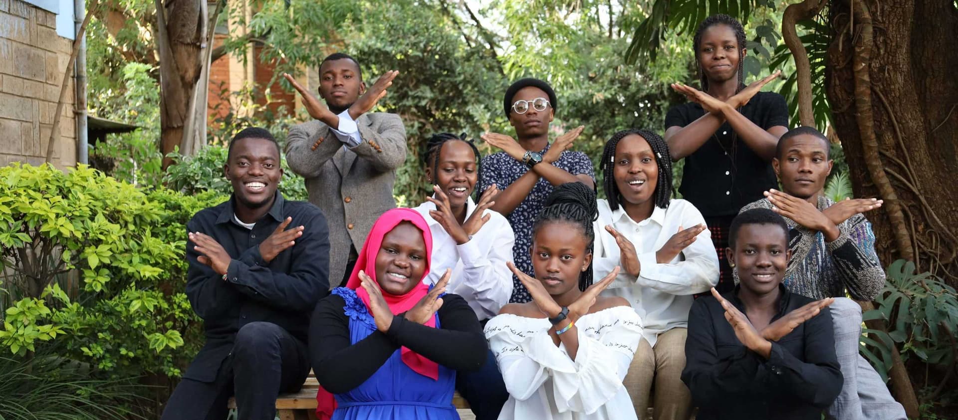 A group of NairoBits students crossing their arms in the Break the Bias pose